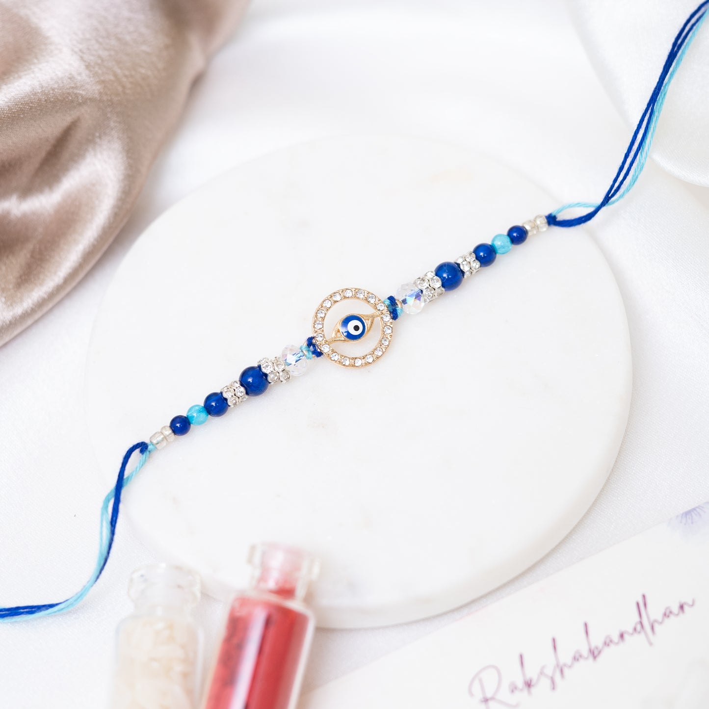Evil Eye Metal Disc Rakhi With Roli Chawal Set