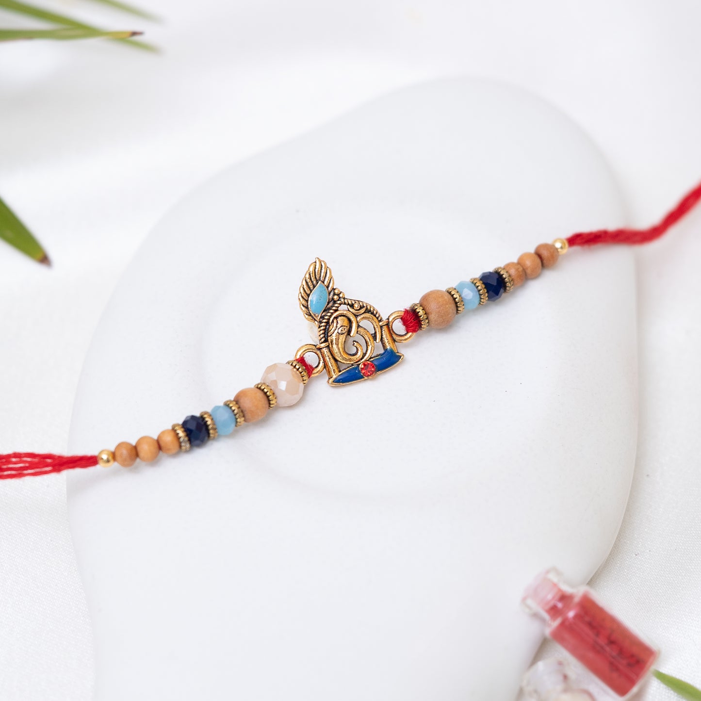 Antique Ganesha Rakhi Adorned with Rich Beads with Roli Chawal Set