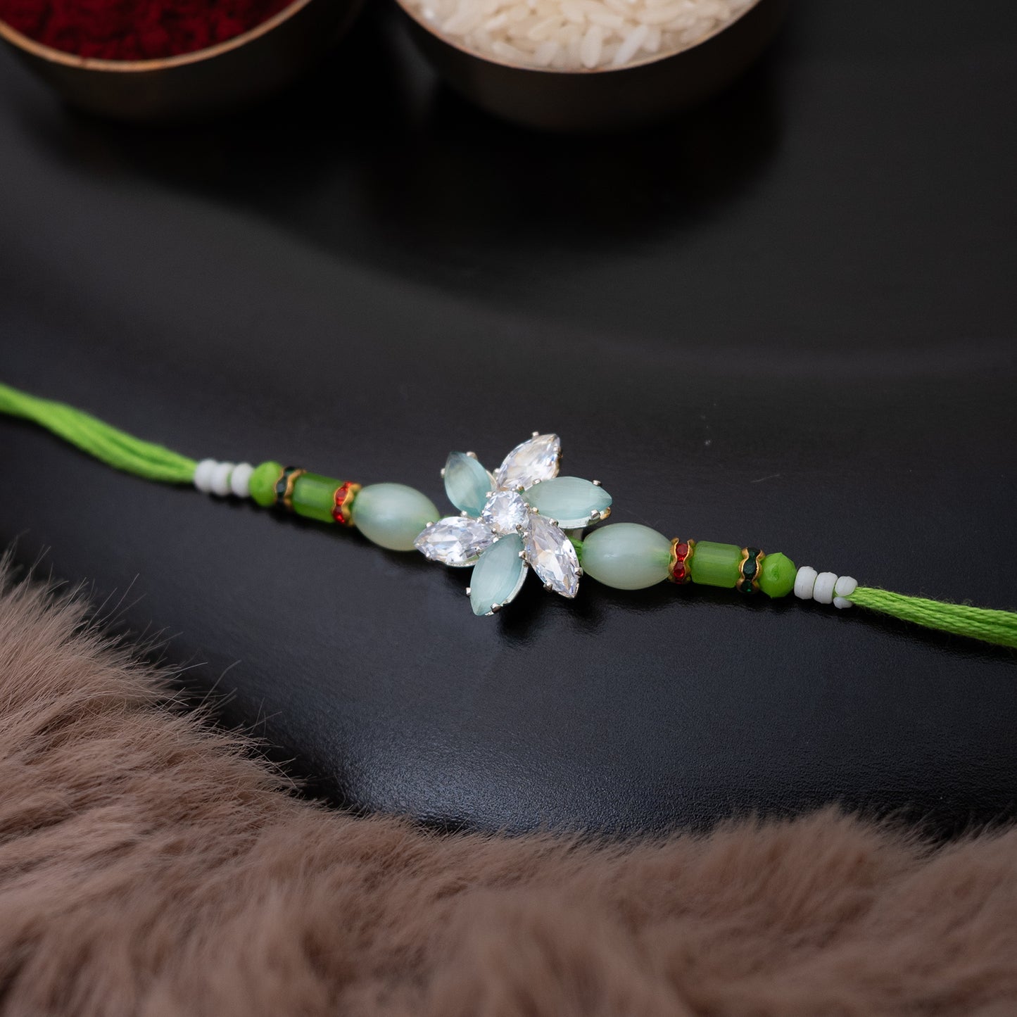 Crystal Blossom Rakhi in light green Colour With Roli Chawal Set