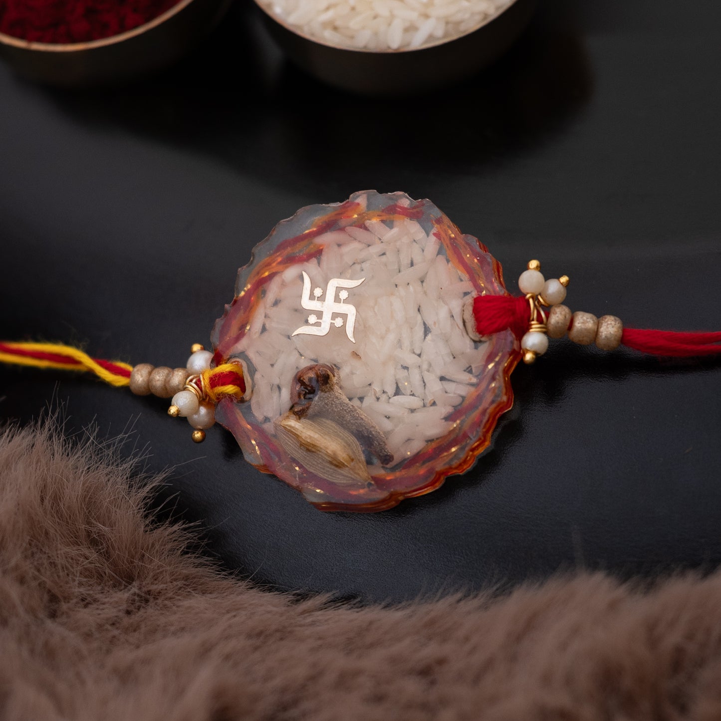 Laung, elaichi Resin Rakhi with mauli, rice and swastik blessing with set of ROLI CHAWAL