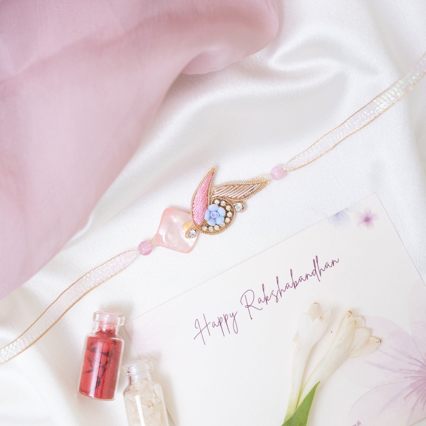 Designer rakhi in soft pink with roli chawal set