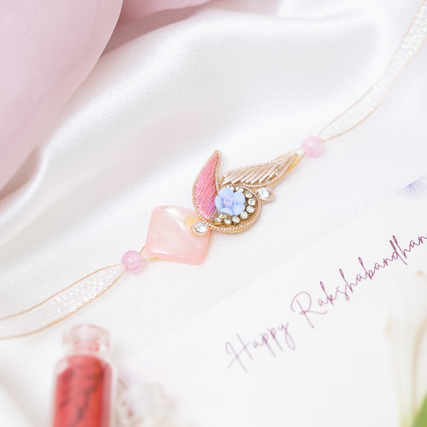 Designer rakhi in soft pink with roli chawal set