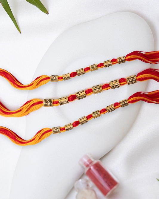 Red-Yellow Rakhi with Antique Charm set of 3 with Roli Chawal Set