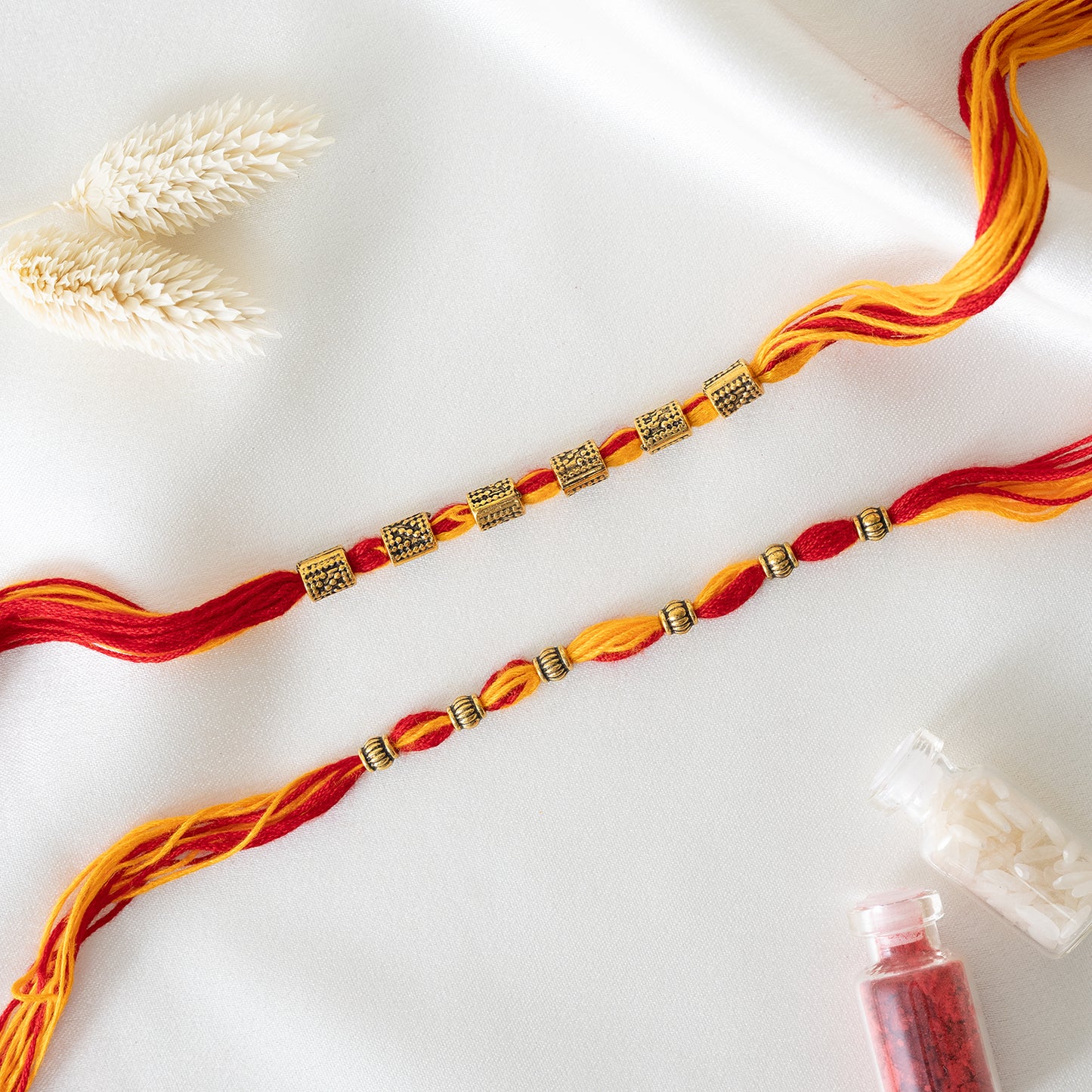 Red Yellow Rakhi with Antique Charm. Set of 2 With Roli Chawal Set