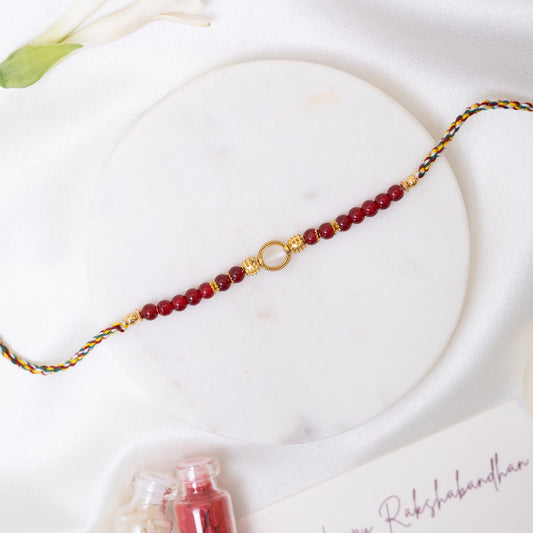 Red Pearl & White Stone Rakhi with Golden Accents With Roli Chawal Set