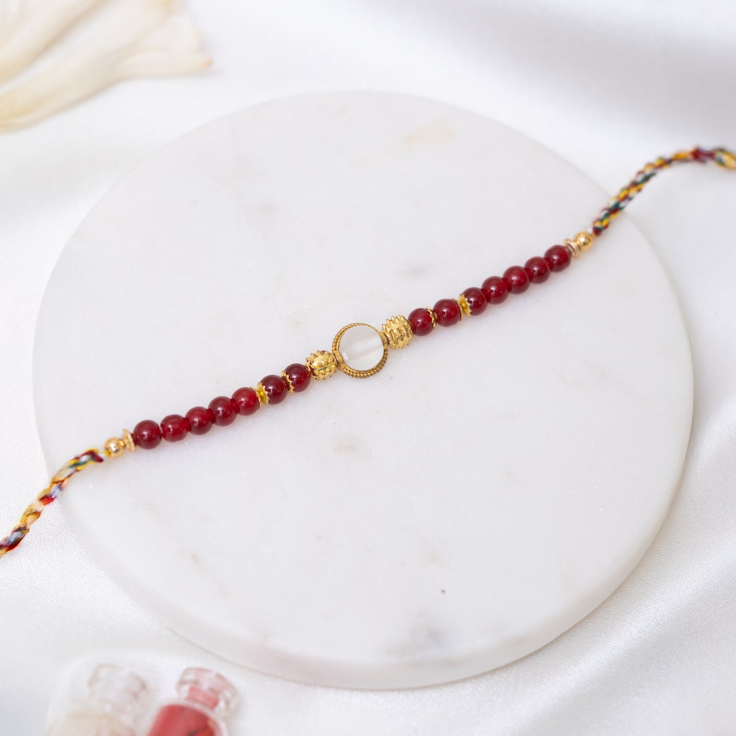 Red Pearl & White Stone Rakhi with Golden Accents With Roli Chawal Set