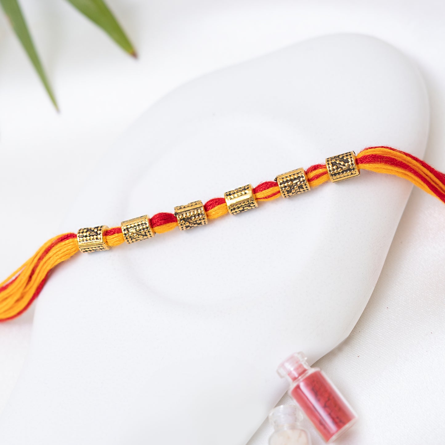 Red-Yellow Rakhi with Antique Charm set of 3 with Roli Chawal Set