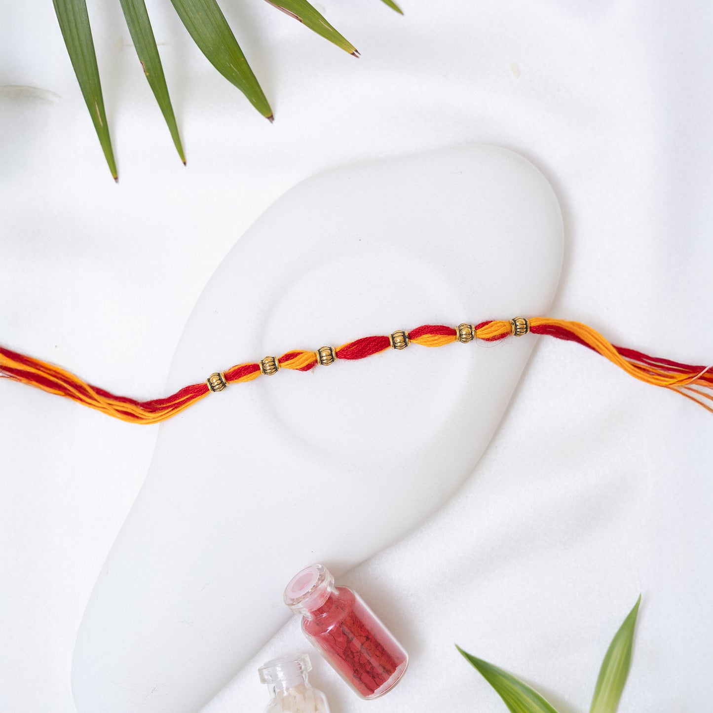 Red-Yellow Rakhi with small Antique Charm set of 3 with Roli Chawal Set